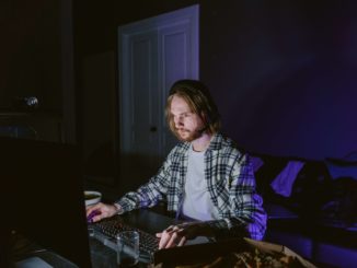 hombre sentado en computador jugando los mejores proyectos play-to-earn