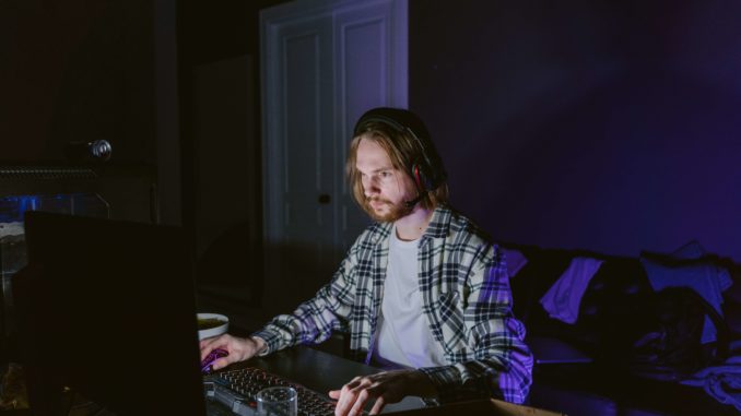 hombre sentado en computador jugando los mejores proyectos play-to-earn